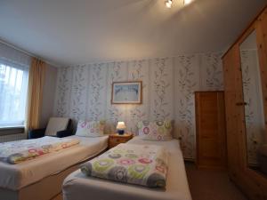 a hotel room with two beds and a chair at Wonderful Apartment in Elpe with Garden in Kröpelin