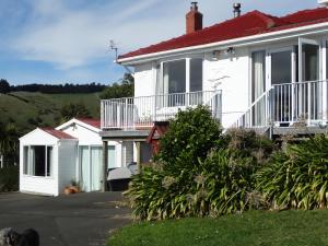 ein weißes Haus mit rotem Dach in der Unterkunft Piringa in Dunedin