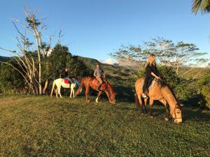 a group of people riding horses in a field at La Vieille Cheminee in Chamarel