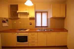 a small kitchen with a sink and a stove at App with a lovely patio in Mali Lošinj