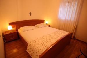 a bedroom with a bed and a cross on the wall at App with a lovely patio in Mali Lošinj