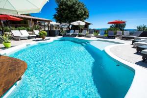 - une piscine avec une table et des chaises dans l'arrière-cour dans l'établissement Les Chalets en Cévennes, à Saint-Christol-lès-Alès