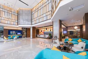 a large lobby with blue couches and chairs at Hampton by Hilton Zhengzhou High-Tech Zone in Zhengzhou