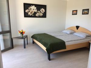 a bedroom with a bed and a vase of flowers at Centuria Domek Letniskowy in Władysławowo