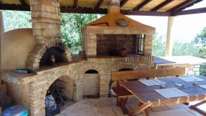 an outdoor oven with a table and a wooden bench at Spiros & Dimitris View House in Nisakion