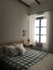 コルドバにあるApartamento Completo Santa Marinaのベッドルーム1室(チェック入りの毛布、窓付)