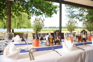 a table with wine glasses and napkins on it at Strandhaus am Inselsee in Güstrow
