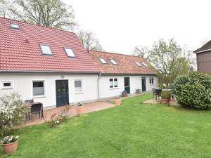 a white house with a red roof and a yard at Wohnung in Stellshagen, Niklas in Stellshagen