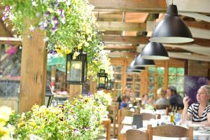 un restaurante con gente sentada en mesas y flores en Canyon Matka Hotel, en Matka