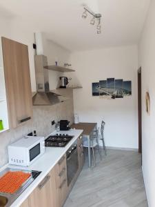 a kitchen with a stove and a microwave at Karina House-check in H 24 in Como