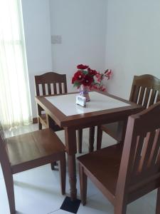 a wooden table and chairs with a vase of flowers on it at Andres Resort in Nabas