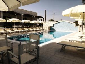 - une piscine avec des chaises et un parasol dans l'établissement Residence Bandiera Gialla, à Margherita di Savoia