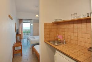 a kitchen with a sink and a room at Ostria in Patitiri