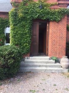 ein Backsteinhaus mit einer Treppe, die zu einer Tür führt in der Unterkunft Liebacksgården in Skegrie