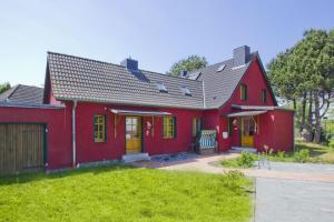ティースゾーにあるFerienhaus Utkiek Soe - Terrasse, Garten, strandnahの黄色い扉と庭のある赤い家