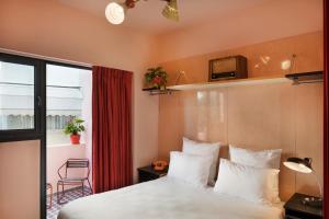 a bedroom with a bed and a tv on the wall at Scarlet Hotel in Tel Aviv