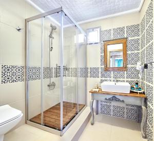a bathroom with a shower and a toilet and a sink at Fİ Light Solto Boutique Beach Hotel in Selimiye