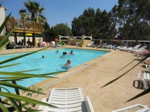 een groep mensen die zwemmen in een zwembad bij Camping les Acacias in Fréjus