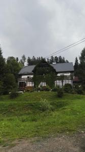 a large house with a grass field in front of it at Willa Pod Dobrym Humorem in Miedzygorze