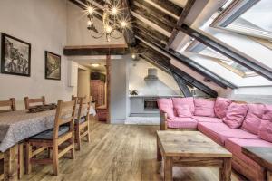 - un salon avec un canapé rose et une table dans l'établissement Apartment Mansard, à Chamonix-Mont-Blanc