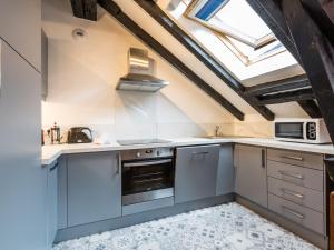 a kitchen with gray cabinets and a window at Apartment Mansard in Chamonix