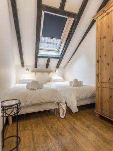 two beds in a attic bedroom with a skylight at Apartment Mansard in Chamonix-Mont-Blanc