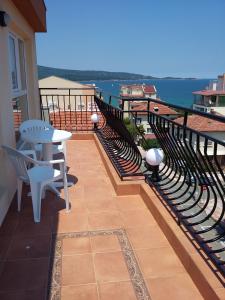 a balcony with a table and chairs and the ocean at Guest House Adriya in Primorsko