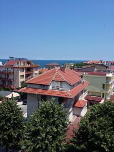 a group of buildings with red roofs and trees at Guest House Adriya in Primorsko