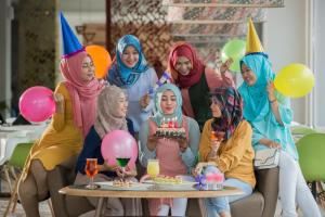 um grupo de mulheres em uma festa de aniversário com um bolo em KHAS Surabaya em Surabaya