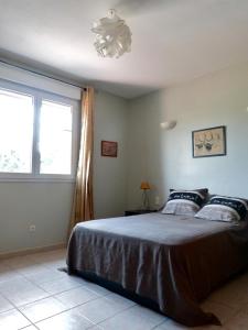 Schlafzimmer mit einem Bett und einem Fenster in der Unterkunft Chambres Salvaterra in Sauveterre