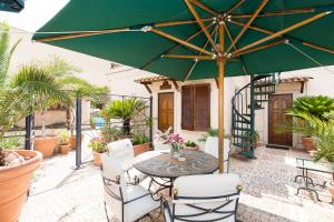 a patio area with a table, chairs and umbrella at Hotel Celio in Rome