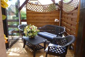 un patio con mesa, sillas y un jarrón de flores en les lilas, en Ammerschwihr