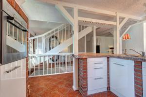 una cocina con armarios blancos y una escalera en Haus Kieferngrund, en Ahlbeck