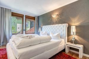 - une chambre avec un grand lit blanc et une fenêtre dans l'établissement Haus Kieferngrund, à Ahlbeck