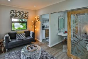 a living room with a couch and a table at Kingsley House Chalet in Ballito