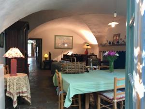 a dining room with a table and a living room at Les Asphodèles in Saint-Hippolyte-du-Fort