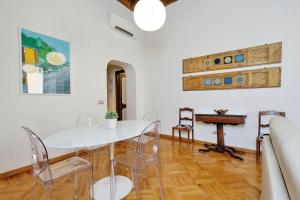 een eetkamer met een witte tafel en stoelen bij Giulia Charme - My Extra Home in Rome