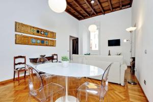 una sala de estar blanca con mesa blanca y sillas en Giulia Charme - My Extra Home, en Roma