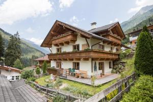 dom w górach z drewnianym tarasem w obiekcie Stubaier Gletscher XL Apartments Residenz Haus Alpenkönig Ferienwohnungen im alpinen Charme Stubai super Card Inklusive w Neustift im Stubaital