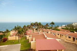 a row of houses with the ocean in the background at First Group Chaka's Rock Chalets in Ballito