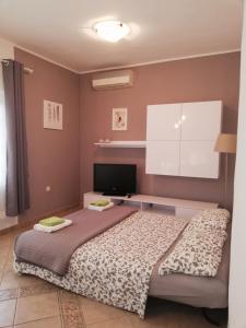 a bedroom with a bed and a flat screen tv at Apartments Merlin in Novigrad Istria