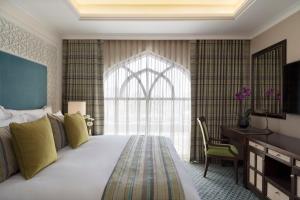 
a bedroom with a large bed and a large window at Al Najada Doha Hotel by Tivoli in Doha
