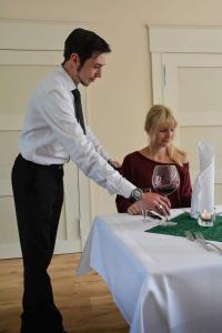 a man standing next to a woman at a table at Wildhof in Neustrelitz