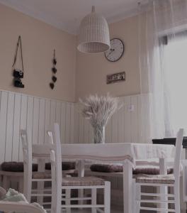 a dining room with a table and chairs and a clock at Gogalova Apartment in Ljubljana