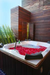 een bad gevuld met rode rozenblaadjes bij Singha Montra Lanna Boutique Style Hotel in Chiang Mai