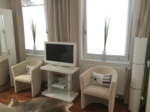 a living room with two chairs and a computer monitor at Chic - Dein City-Apartment I Küche I Boxspringbett I in Braunschweig