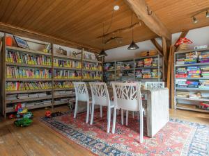 a room with a table and chairs and bookshelves at Chalet in Netherlands with Scenic Meadow Views in Heeten