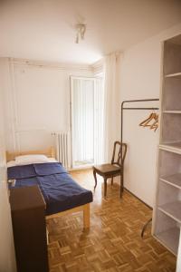 ein Schlafzimmer mit einem Bett und einem Stuhl darin in der Unterkunft Stan u samom centru Obrenovca, na Trgu in Obrenovac