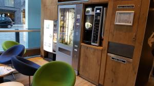 eine Getränkemaschine in einem Restaurant mit grünen Stühlen in der Unterkunft ibis budget Hamburg St Pauli Messe in Hamburg