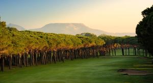 un campo de golf con árboles y montañas al fondo en Casa adosada en Playa de Pals by Apartaments Golf en Pals